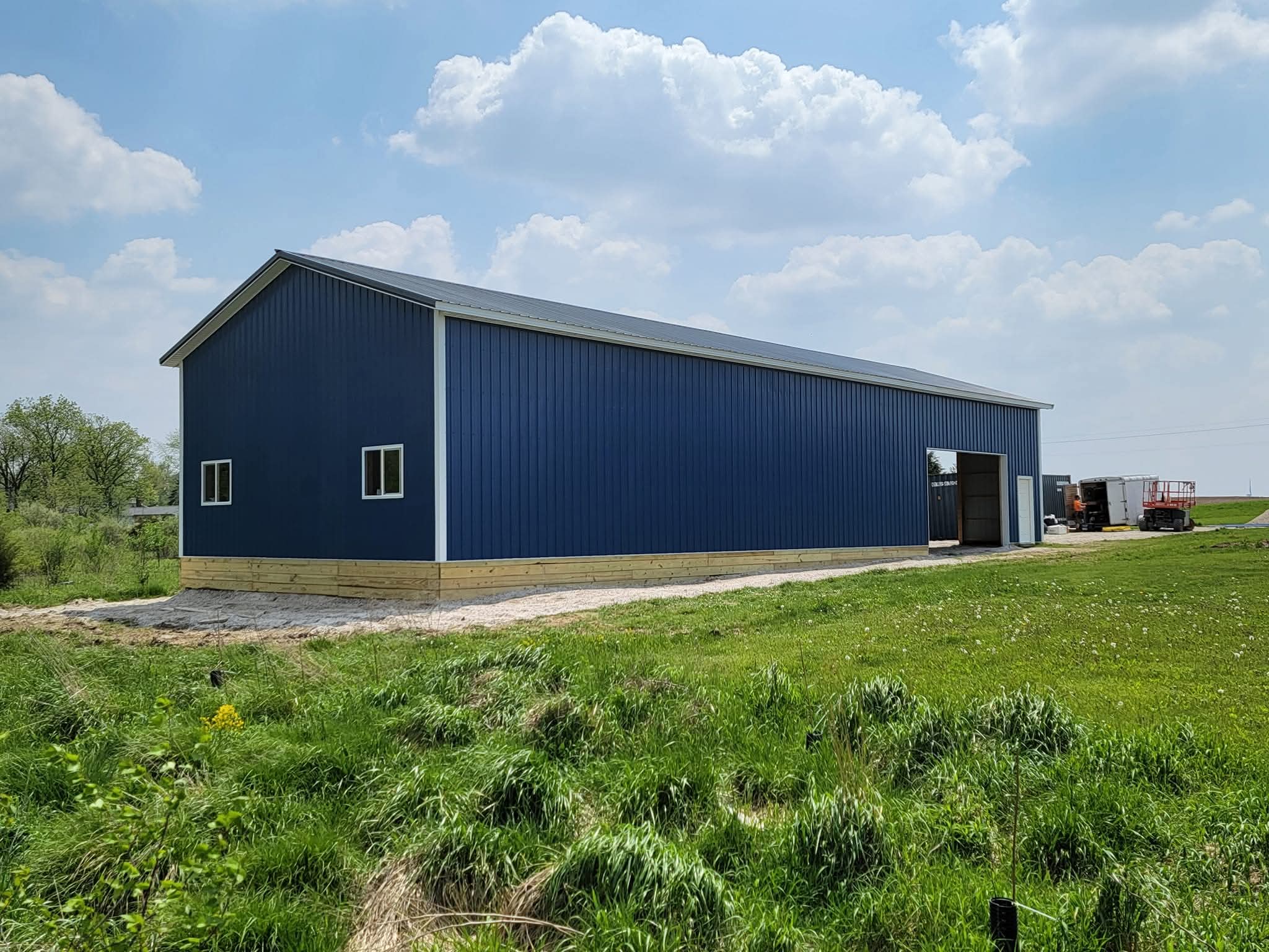 Exterior side view showing the blue steel siding, windows, and long 80-foot building length