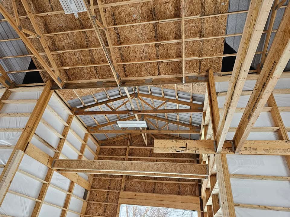 Additional interior framing view of tall post frame shop with charcoal steel siding in Morris Illinois