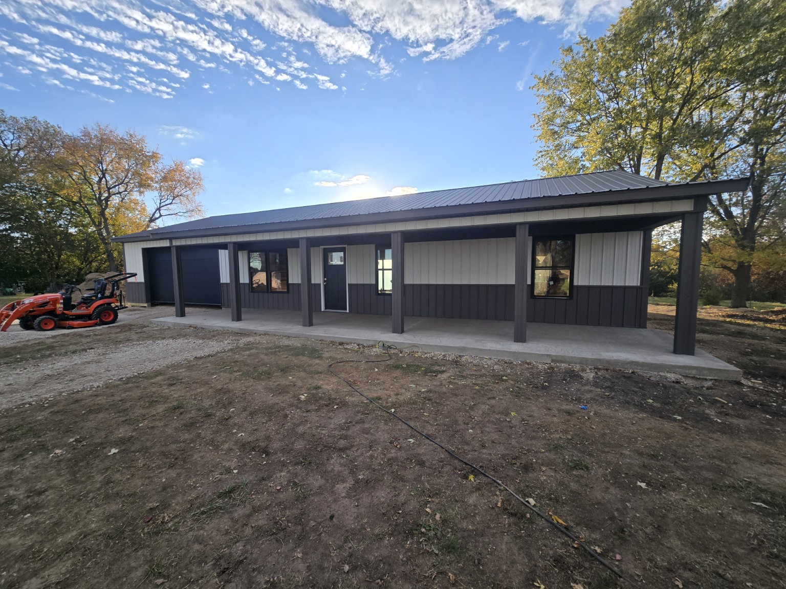 32x64 barndominium front elevation showing full-length covered porch and two-tone steel siding in Ottawa Illinois
