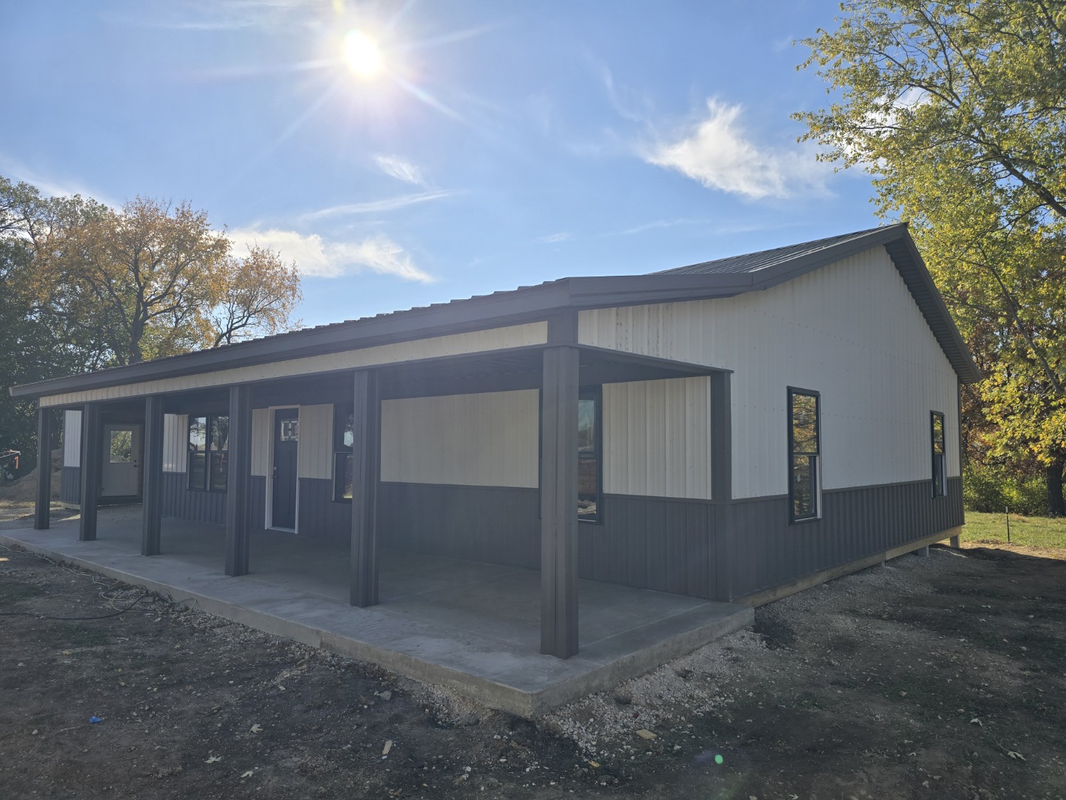 Side angle of 32x64 barndominium with covered porch and two-tone metal exterior in Ottawa Illinois