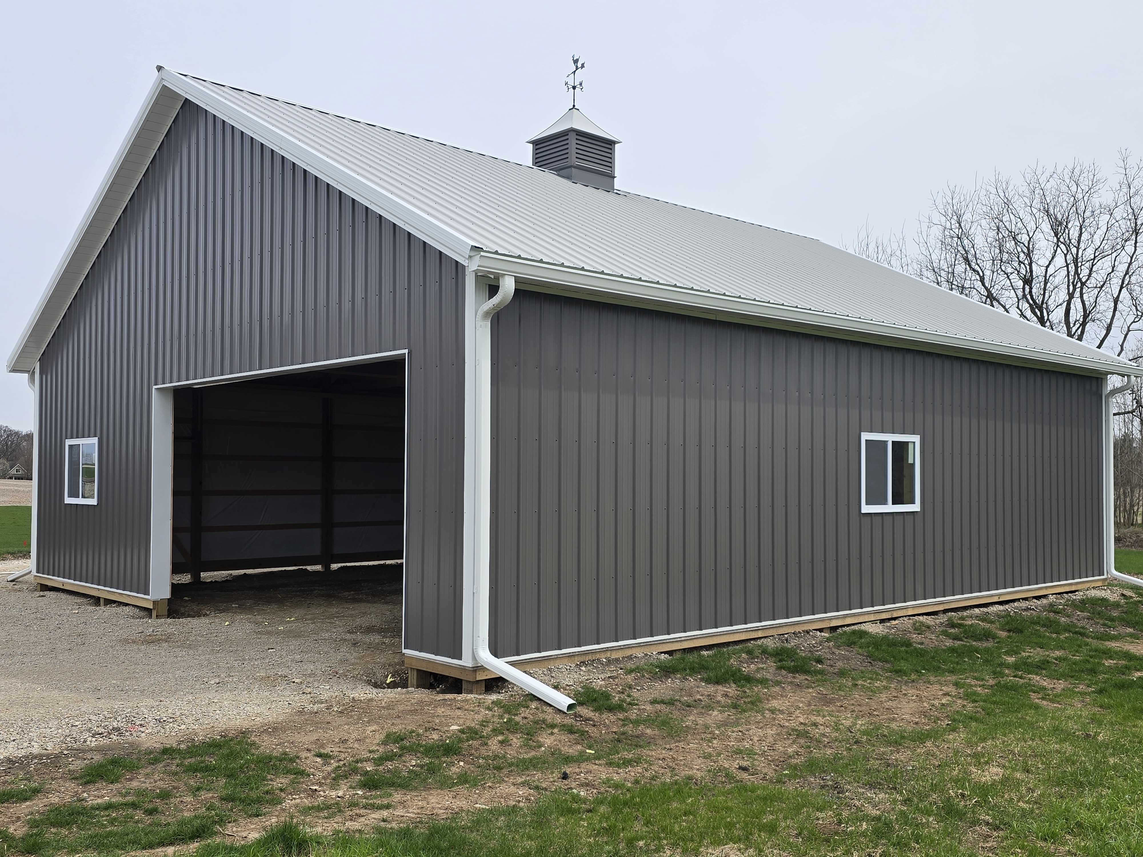 Front exterior of 36x40 pole barn with open bay and cupola in Sheridan Illinois